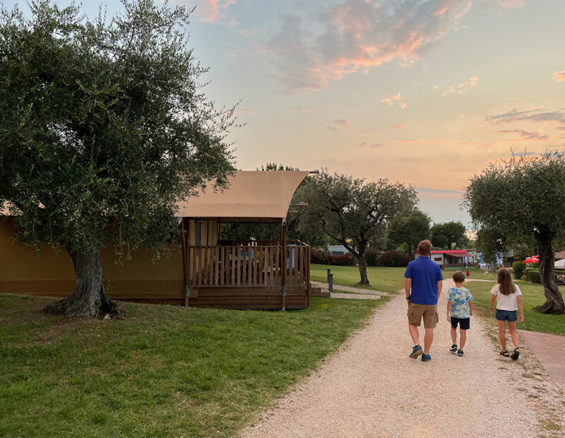 Papà e due bambini passeggiano nel campeggio al Camping Park delle Rose