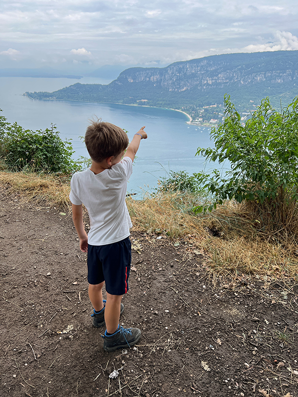 bambino indica il panorama dalla Rocca di Garda sul lago